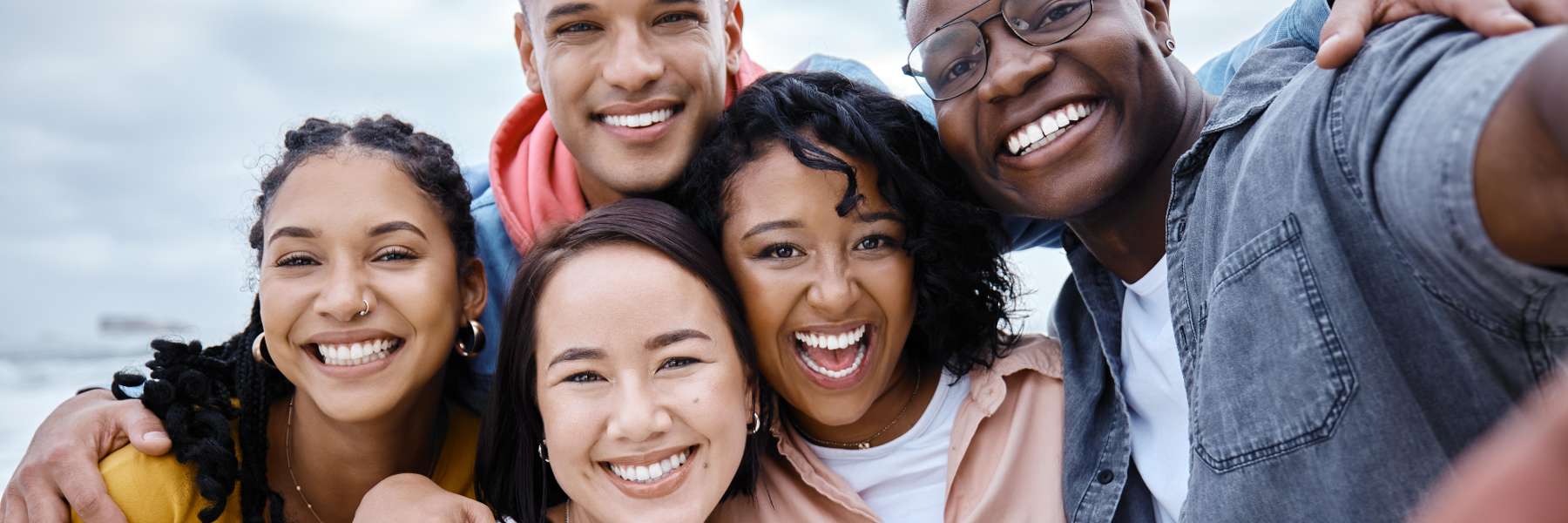 Group of friends smiling brightly with straighter teeth from invisible braces in Bastrop.