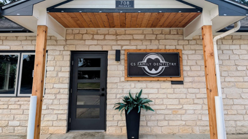 Welcoming exterior entrance of CS Family Dentistry at 708 Pecan Street with stone facade