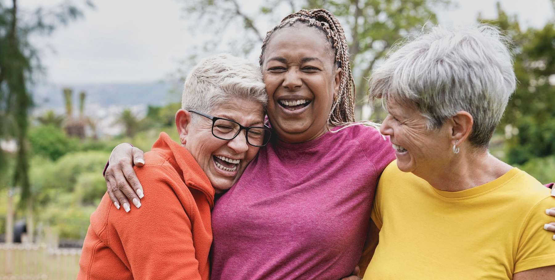 Group of women smiling happily, showcasing restored smiles with custom dentures in Bastrop, TX.